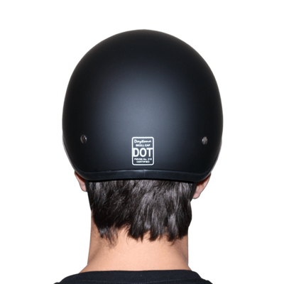 Person wearing a black Daytona D.O.T Skull Cap - w/Wild at Heart helmet with a dot certification sticker.