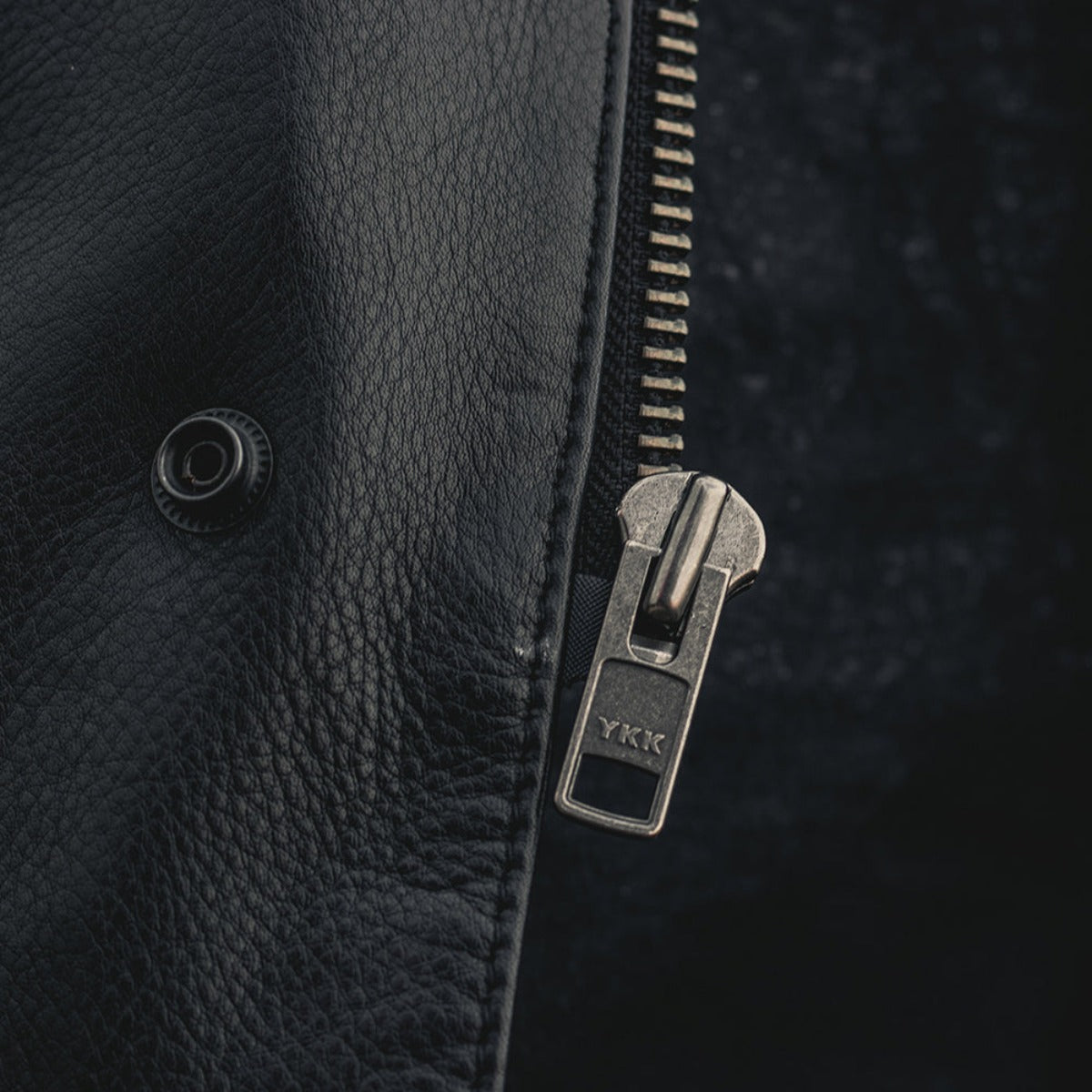A close up of a zipper on the First Manufacturing Sharp Shooter Motorcycle Leather Vest, showcasing the biker style and naked cowhide material.