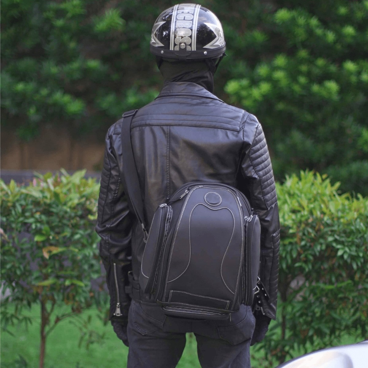 A man wearing a motorcycle helmet and a Universal Motorcycle Retro Tail Bag with Waterproof Cover.