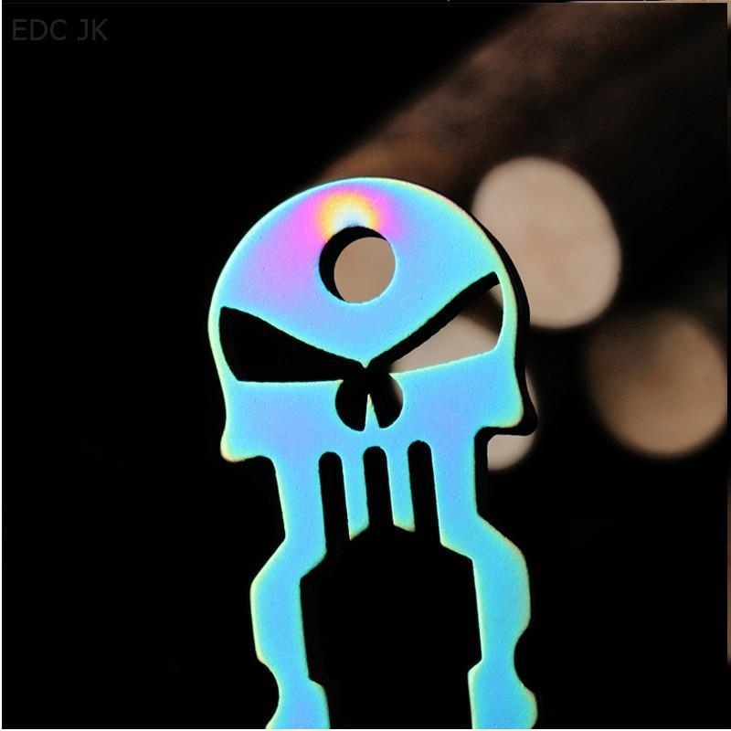 A Skull Survival Tool Keyring is sitting on top of a piece of wood.
