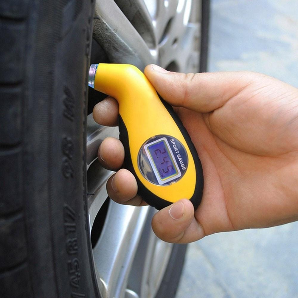 A person is holding a Tire Pressure Tester.