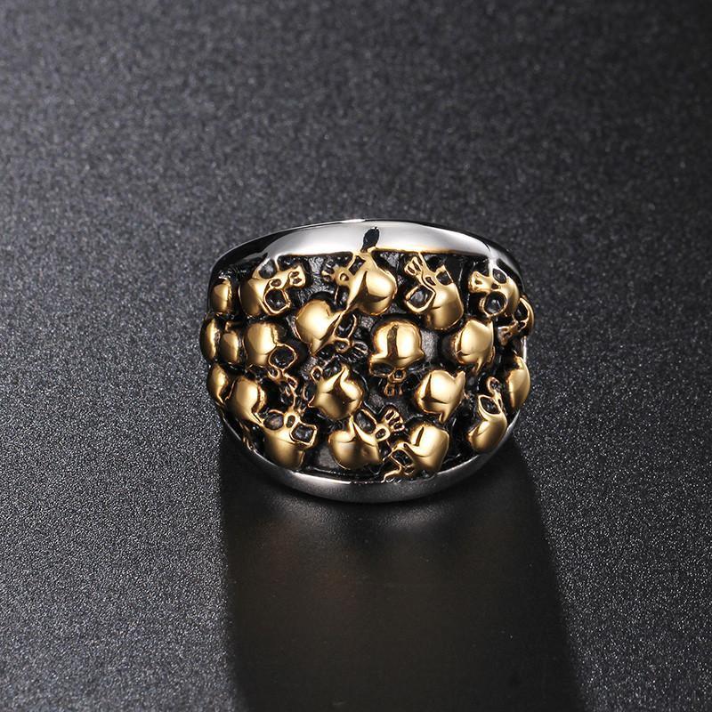 The Stainless Steel Bikers Skeleton Ring, featuring a silver and gold skull, resting on a black surface in true biker style.
