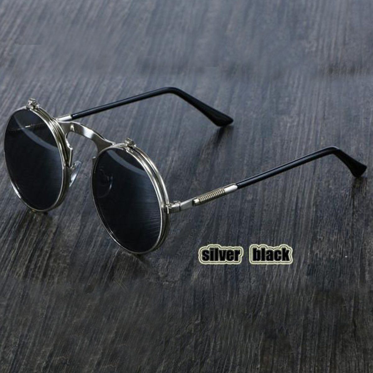 A pair of black Steampunk Flip-Up Round Double Lens sunglasses on a wooden table.