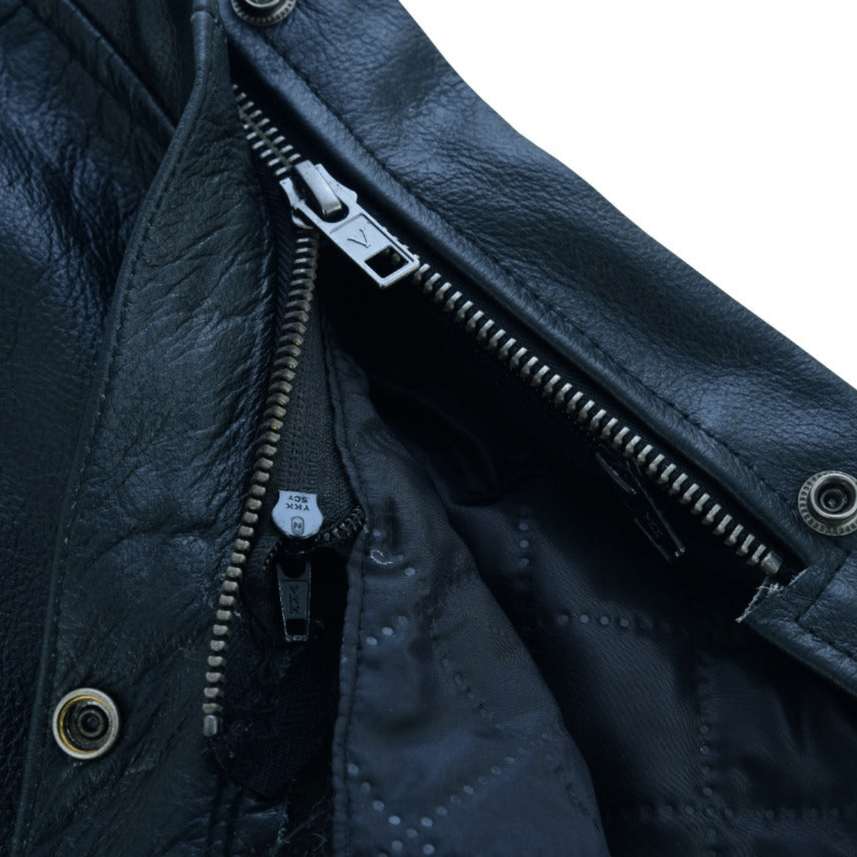 Close-up view of the Vance Zip-Out Insulation Pant Style Motorcycle Leather Chaps highlighting an open metal zipper, snap buttons, and zip-out insulation with quilted inner lining.