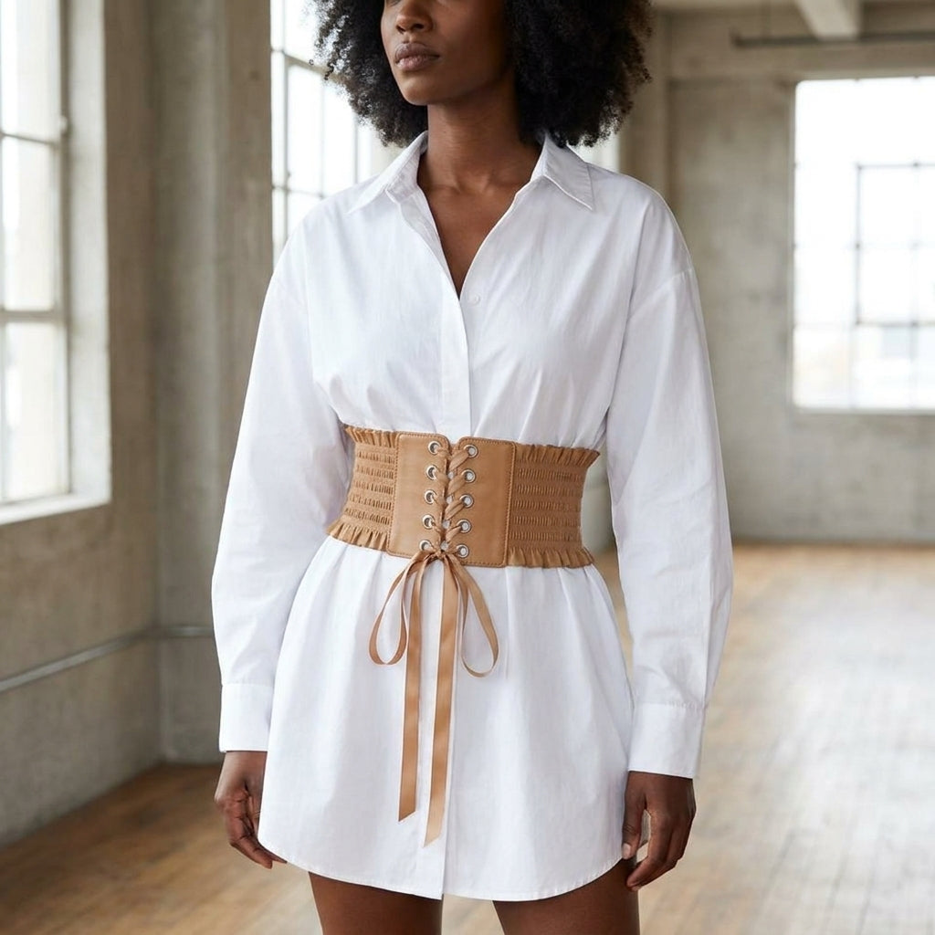 Tan lace up corset belt cinching an oversized white shirt dress at the natural waist