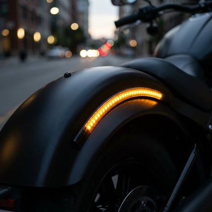 Motorcycle LED light bar strip glowing amber on rear fender of black cruiser