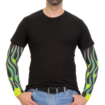 A person wearing a black t-shirt, blue jeans with a black belt, and Hot Leathers Green Flame Arm Sleeve suitable for outdoor activities stands with hands in pockets.