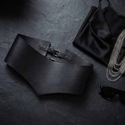 Wide black corset waist belt styled flat with silver chains and sunglasses