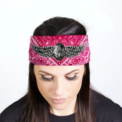 A woman with a biker style wearing a pink Hot Leathers Flying Wheel Shield Bandana Headband Wrap w/Rhinestones featuring a sparkle-adorned eagle.