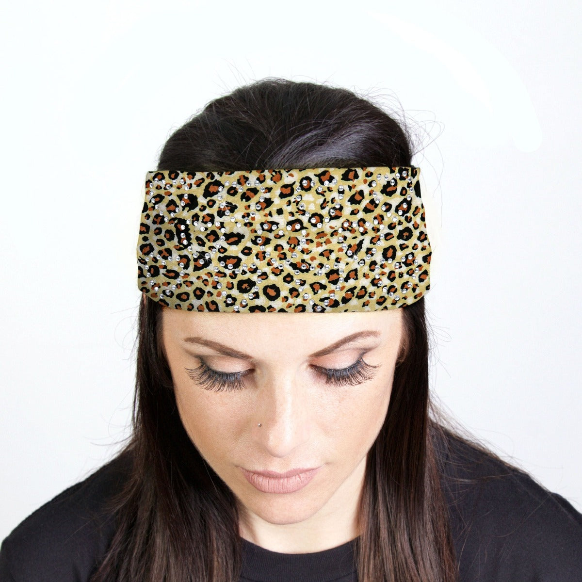 A woman sporting a Hot Leathers Leopard Print Bandana Headband Wraps w/Rhinestones with a touch of biker style.