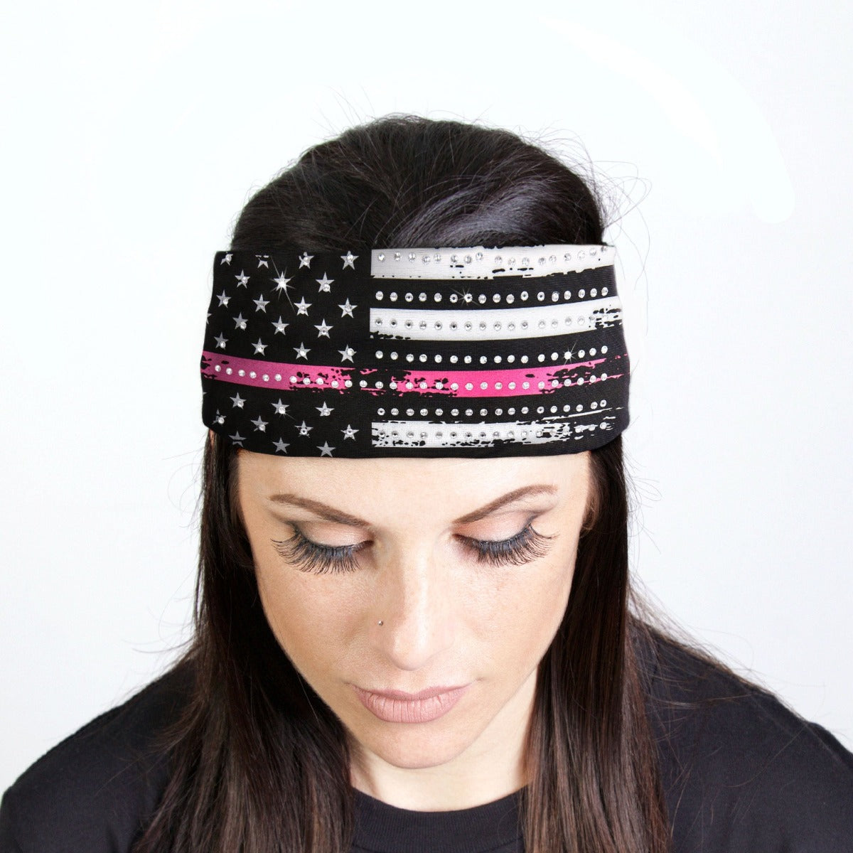 A woman wearing a Hot Leathers Pink Flag Bandana Headband Wrap with Rhinestones adorned with sparkling rhinestone crystals.
