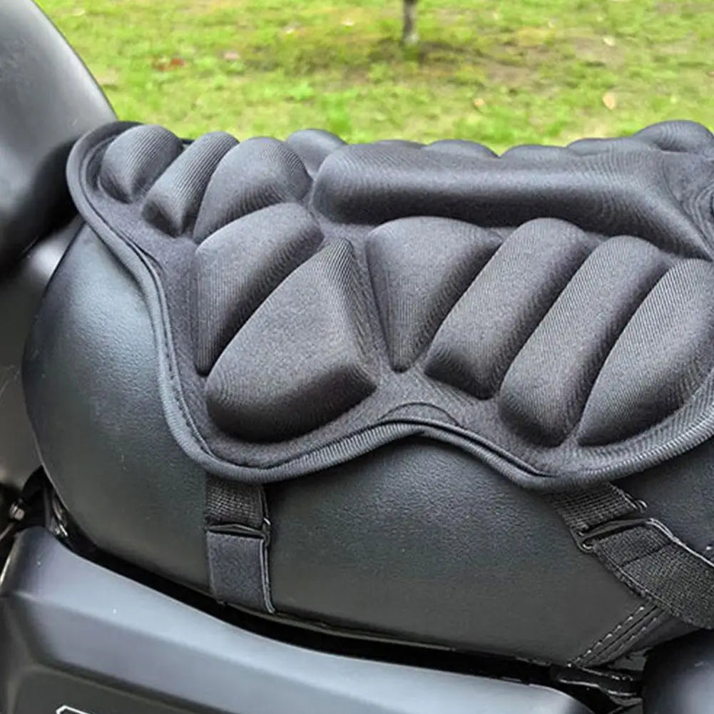 The ALR™ Motorcycle 3D Seat Cushion, in black with an anti-slip design and raised cushioning, is securely strapped to the bike. Grass in the background emphasizes its perfect blend of style and comfort for every ride.