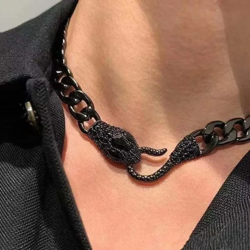 The ALR™ Vintage Punk Viper Necklace features a sleek black chain with an intricate snake motif, gracefully resting on dark fabric.