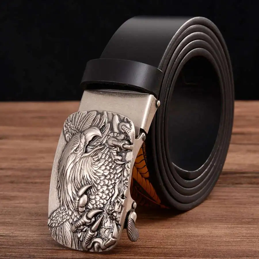 The Alr™ Men's Leather Ratchet Belt showcases a genuine leather strap with an automatic buckle, featuring a black band and an intricately designed silver buckle adorned with a raised eagle pattern.