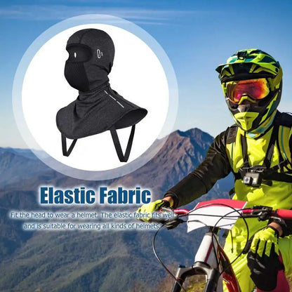 A biker in neon gear confidently rides a mountain bike with the ALR™ Winter Balaclava Neck Warmer, a versatile black elastic accessory ideal for winter sports. The inset reveals its snug fit and functionality as a neck warmer against stunning mountain backdrops.