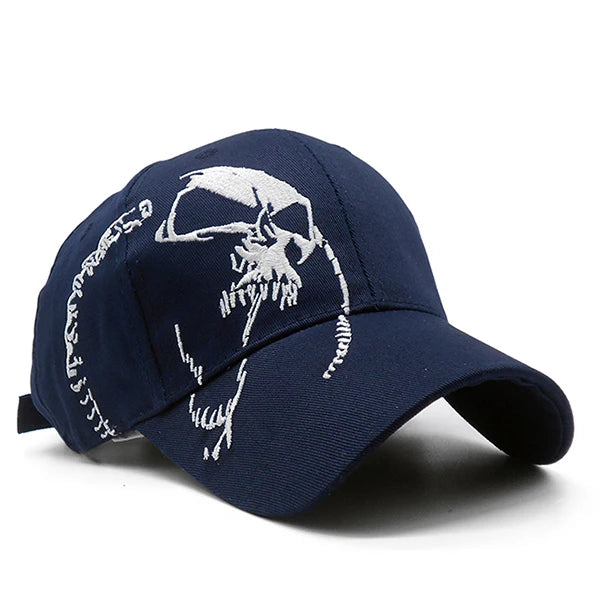 The ALR™ Embroidered Skull Cap is a dark blue baseball hat with an adjustable strap, featuring a white embroidered skull on the front for style and sun protection.