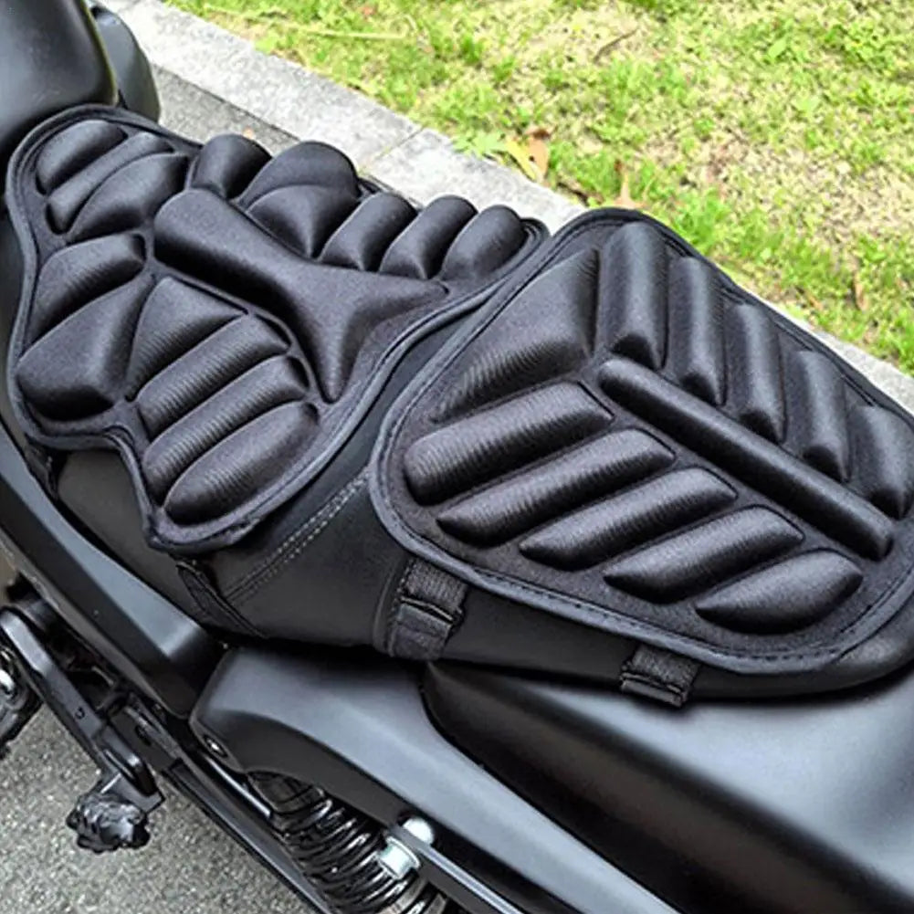 Close-up of an ALR™ Motorcycle 3D Seat Cushion with two black padded sections for ultimate comfort and an anti-slip design, parked on a street beside grassy area.