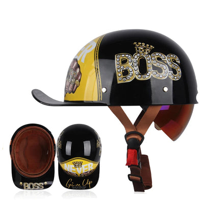 The ALR™ Baseball Cap Motorcycle Helmet showcases a vintage design with a black and yellow scheme, "BOSS" and "NEVER Give Up" text, crown motif, studs, brown straps, and interior padding for lightweight comfort.