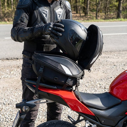 Rider loading a helmet into the ALR motorcycle tail bag