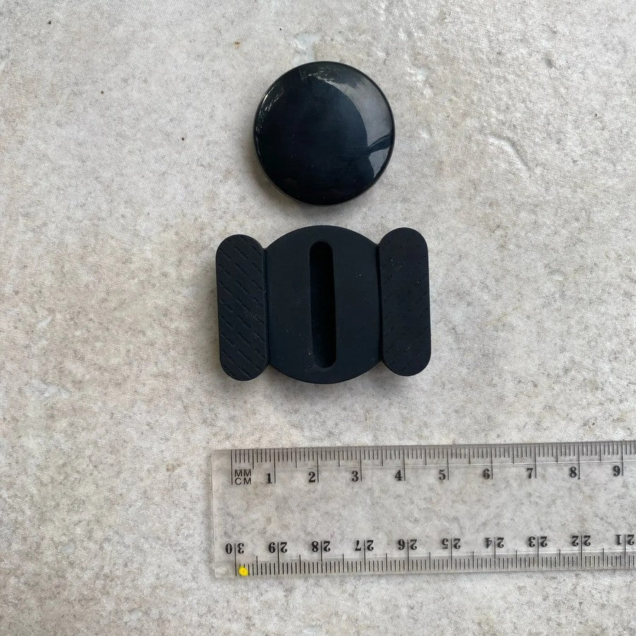 Customer photo of the tracker and its silicone holder beside a ruler for scale