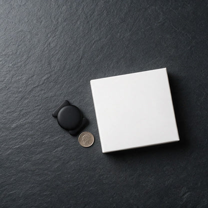 Stealth Bluetooth finder tag beside its box with a coin for scale