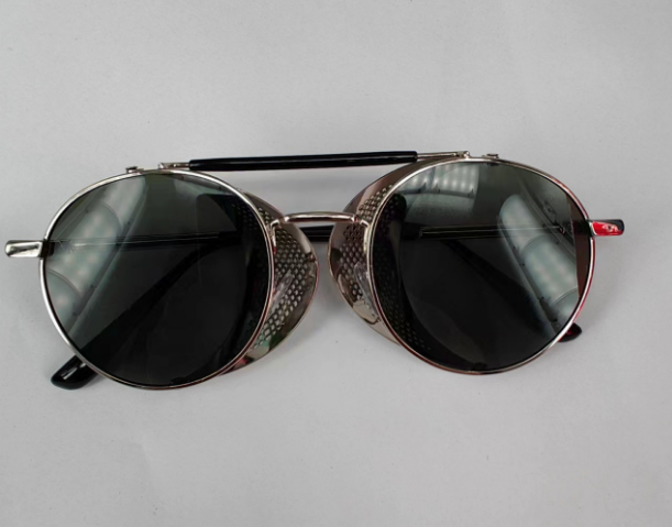 A pair of silver-framed, dark-tinted Bikers Retro Round Steampunk Glasses with a textured design on the side.