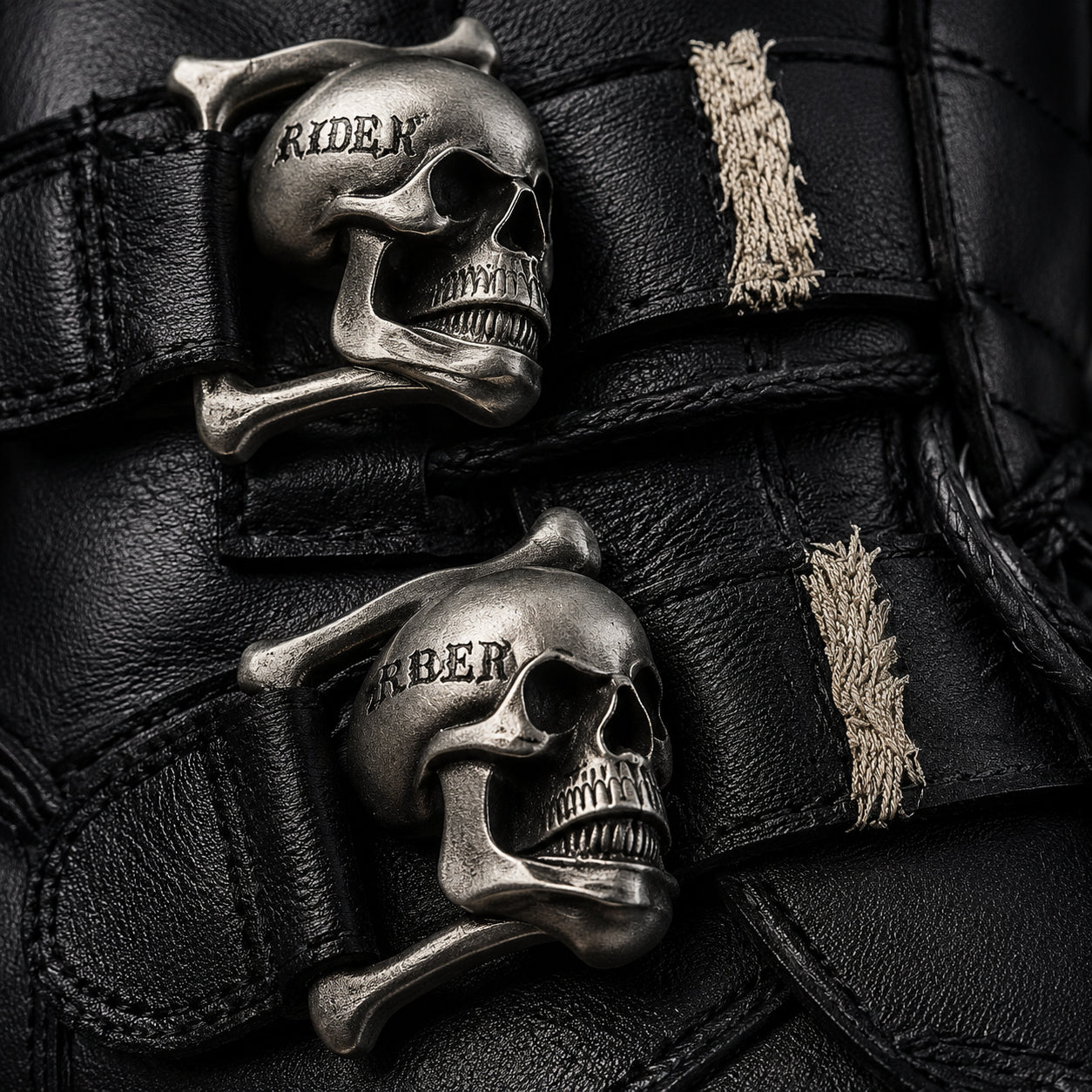 Iron Reign skull buckle hardware close-up showing RIDER text