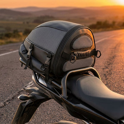 Waterproof tail bag strapped to a motorcycle rear seat at sunset