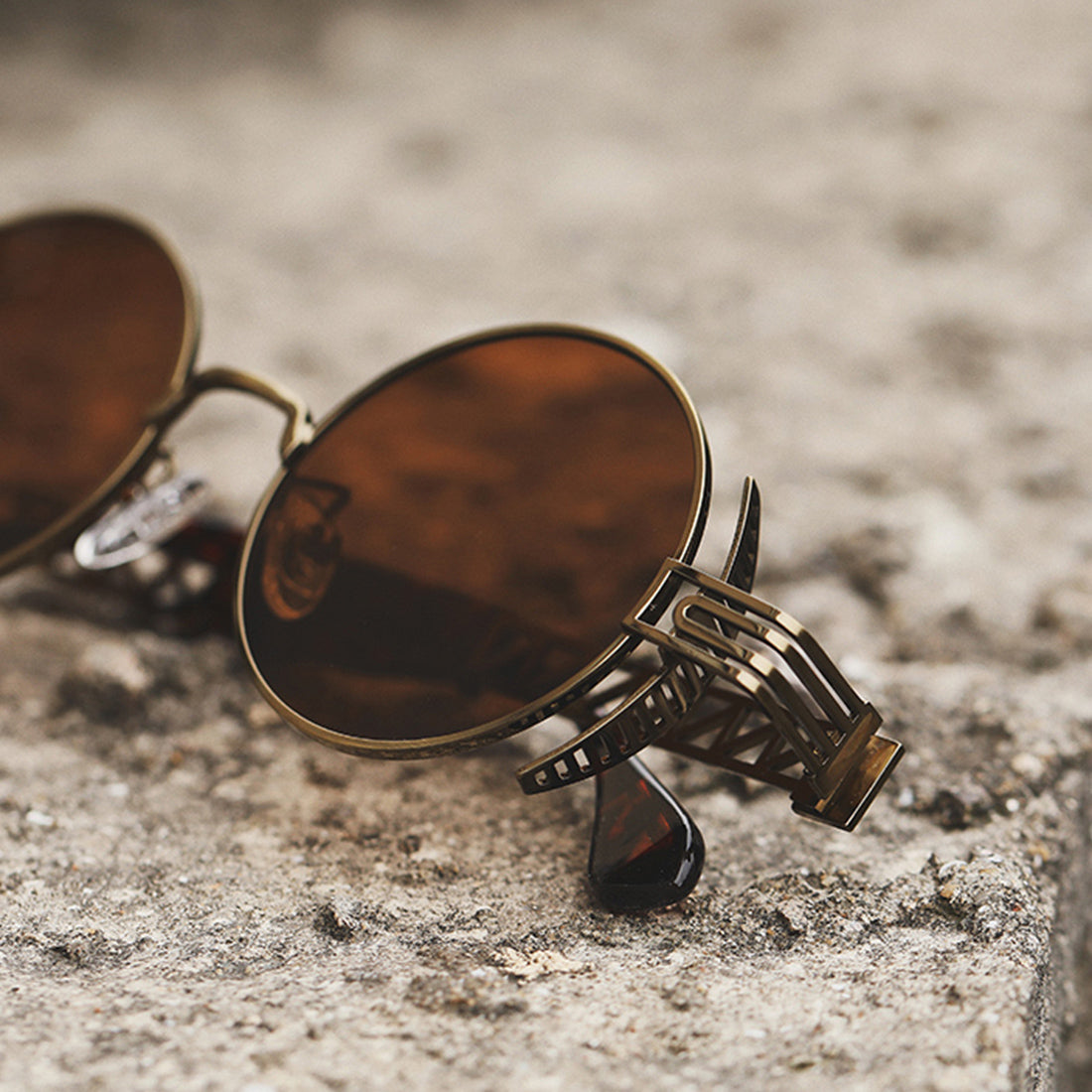 The Rebellion Road Sunglasses, with their vintage retro design, are seen laying on the ground.