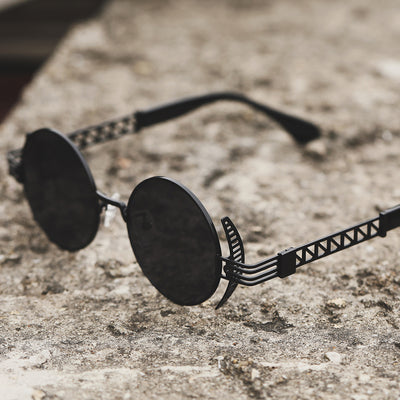 A pair of Rebellion Road Sunglasses on a concrete surface.