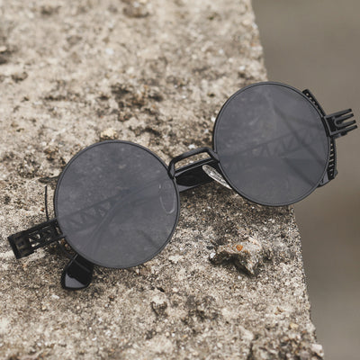 A pair of Rebellion Road sunglasses with a vintage retro design on top of a concrete wall.