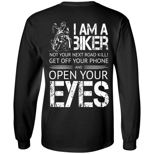 Back view of the Men's I Am A Biker Long Sleeves in black, showcasing white text that reads: "I am a biker, not your next road kill! Get off your phone and open your eyes," along with an illustration of a biker on a motorcycle. The digital print pops on the 100% cotton fabric, ensuring comfort and durability with its unisex sizing.