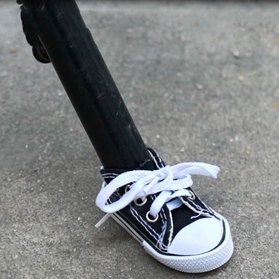 A pair of black and white motorcycle foot support shoes on a portable sidewalk.