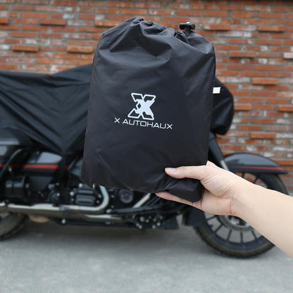 A person holds a black X AUTOHAUX bag in front of a motorcycle, which is protected by the sleek Waterproof Motorcycle Half Cover crafted from durable 210T polyester fabric.