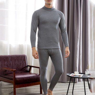 A man in Men's Soft Winter Thermal Underwear - Light Gray standing in front of a couch.