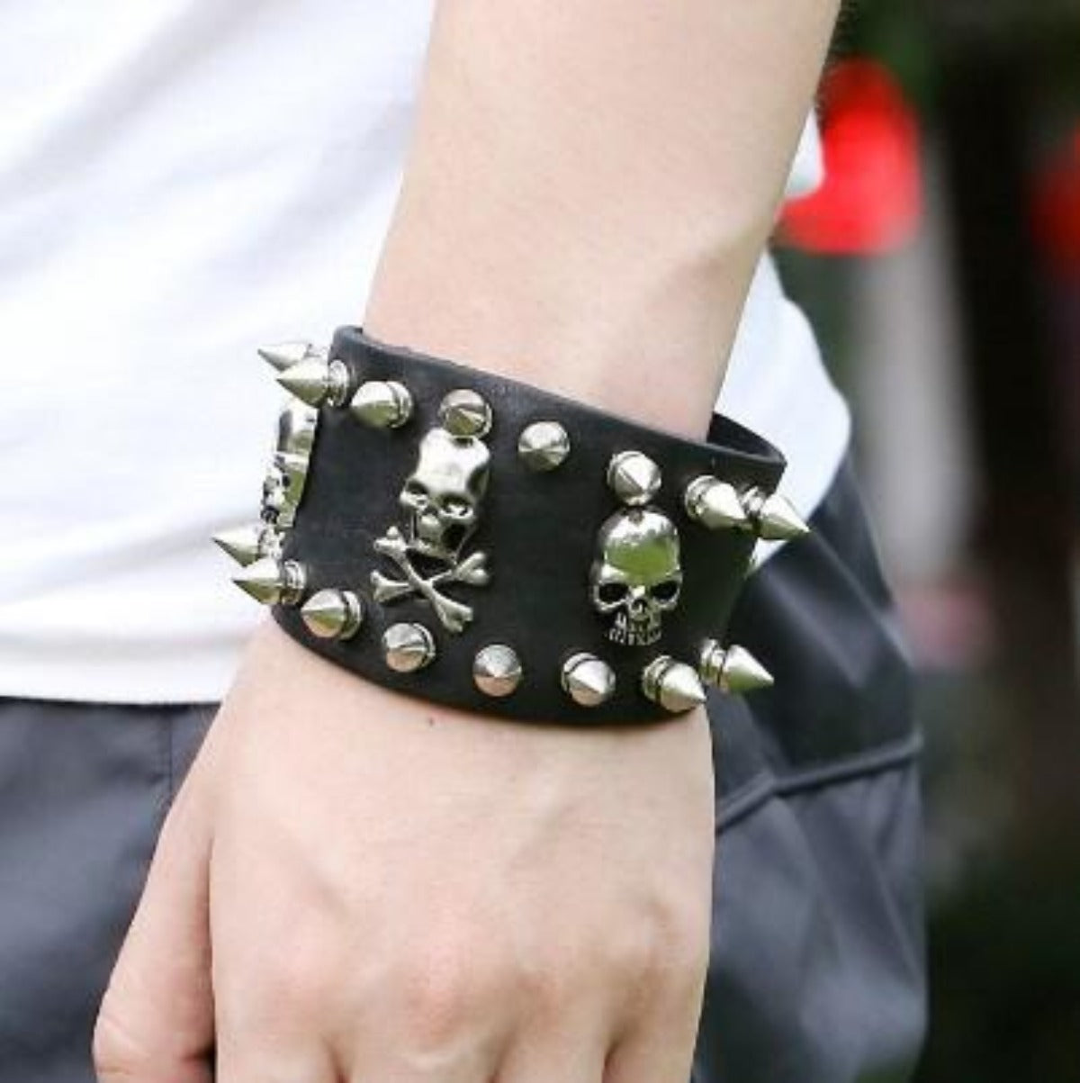 A person wearing Skull & Bones Biker Wristbands with skulls and spikes.