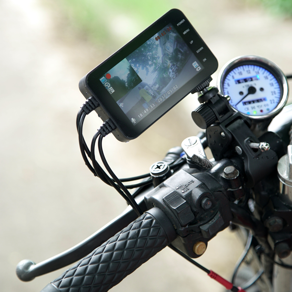 A Motorcycle Dual Lens Dash Camera Video Recorder 4 Inch HD 1080P attached to the handlebars.