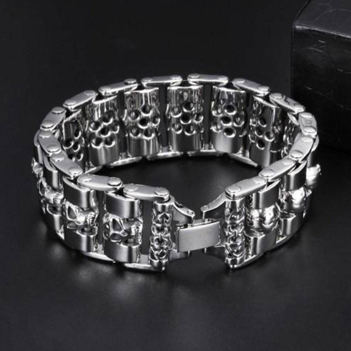 A Stainless Steel Fashion Wide Skull Bracelet, 8.3 x 0.9 in, fastened with a clasp, displayed on a dark, reflective surface.

