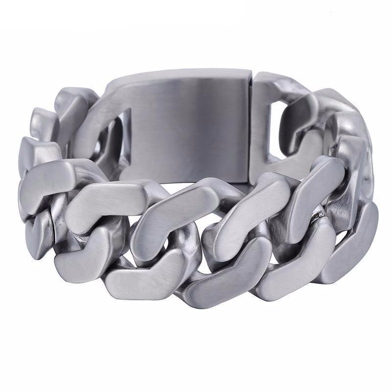 The Stainless Steel Heavy Thick Chain Bracelet boasts a chunky silver design with a width of 1 inch and a thickness of 0.2 inches. This men's accessory features a robust interlocking pattern, complemented by a secure metal clasp, and is rust-resistant for lasting wear.