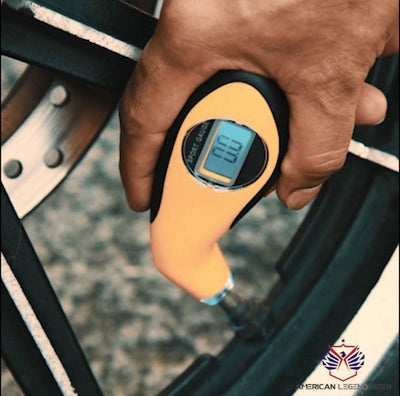 A person is holding a Tire Pressure Tester.
