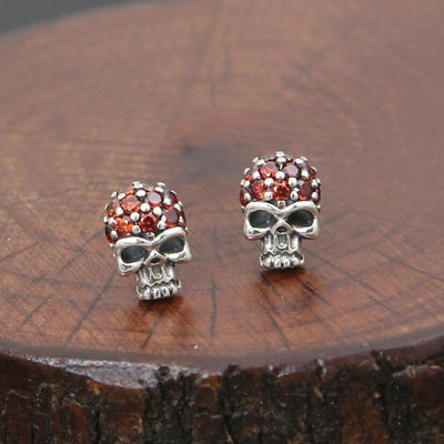 A pair of Fashion Skull Stud Earrings with red crystals.