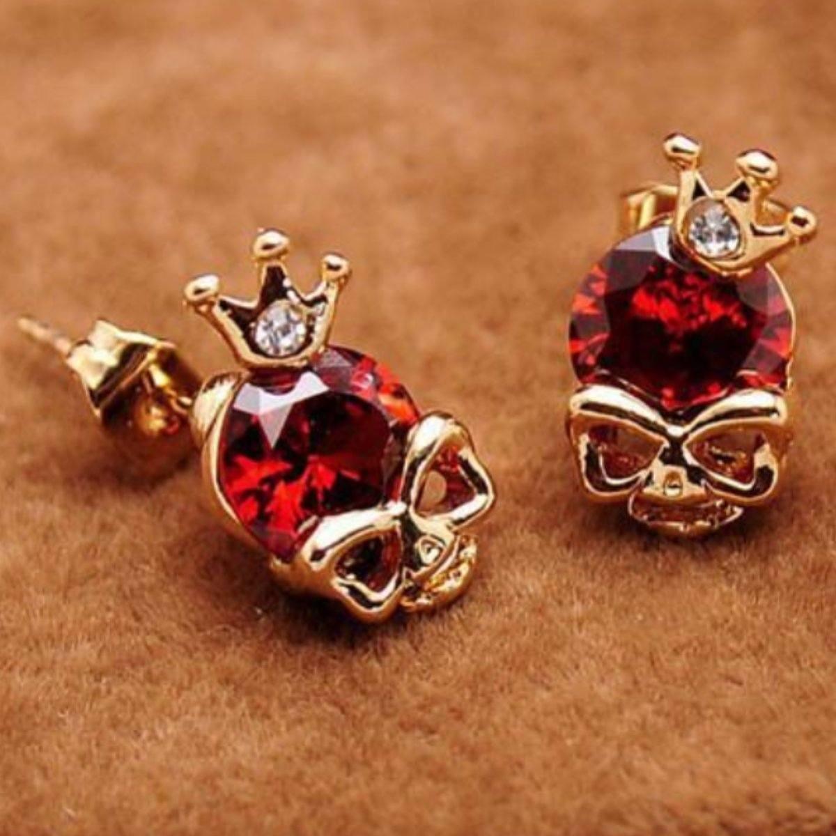 A pair of Woman's Gold Plated Skull Cubic Zircon stud earrings with red crystals.