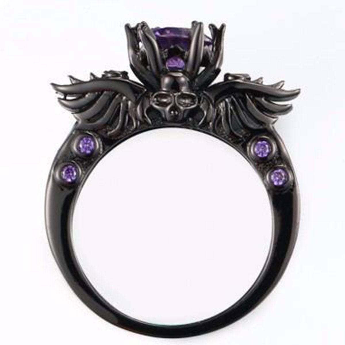 A Vintage Skull Shaped Ring with wings and purple stones.