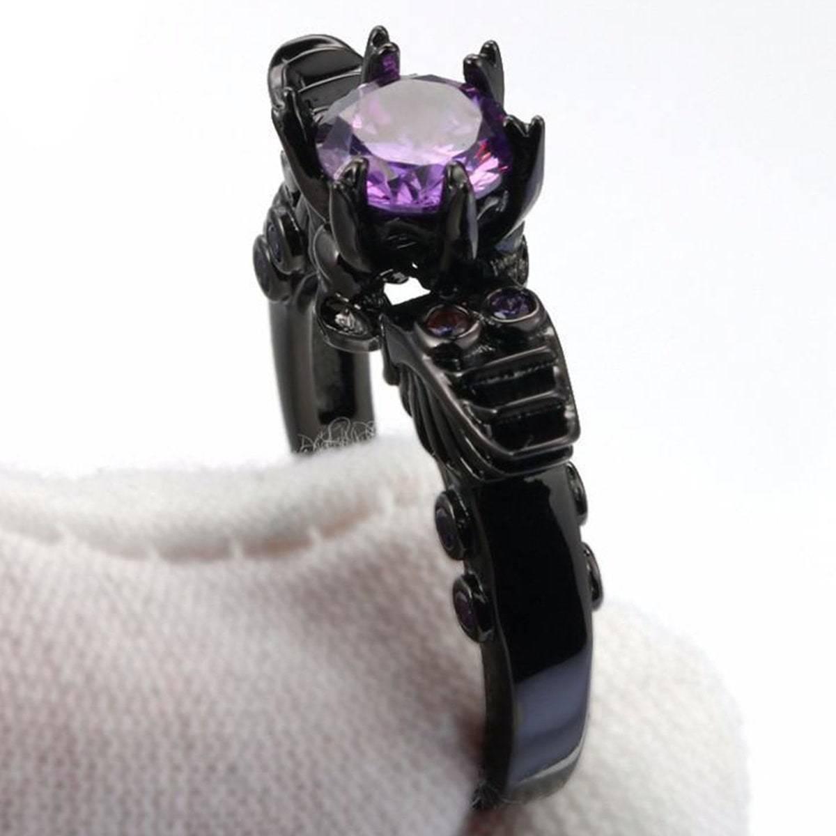 A black and purple Vintage Skull Shaped Ring with an amethyst stone.
