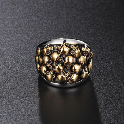 The Stainless Steel Bikers Skeleton Ring, featuring a silver and gold skull, resting on a black surface in true biker style.