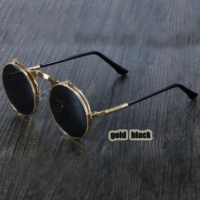 A pair of Steampunk Flip-Up Round Double Lens sunglasses on a wooden table.