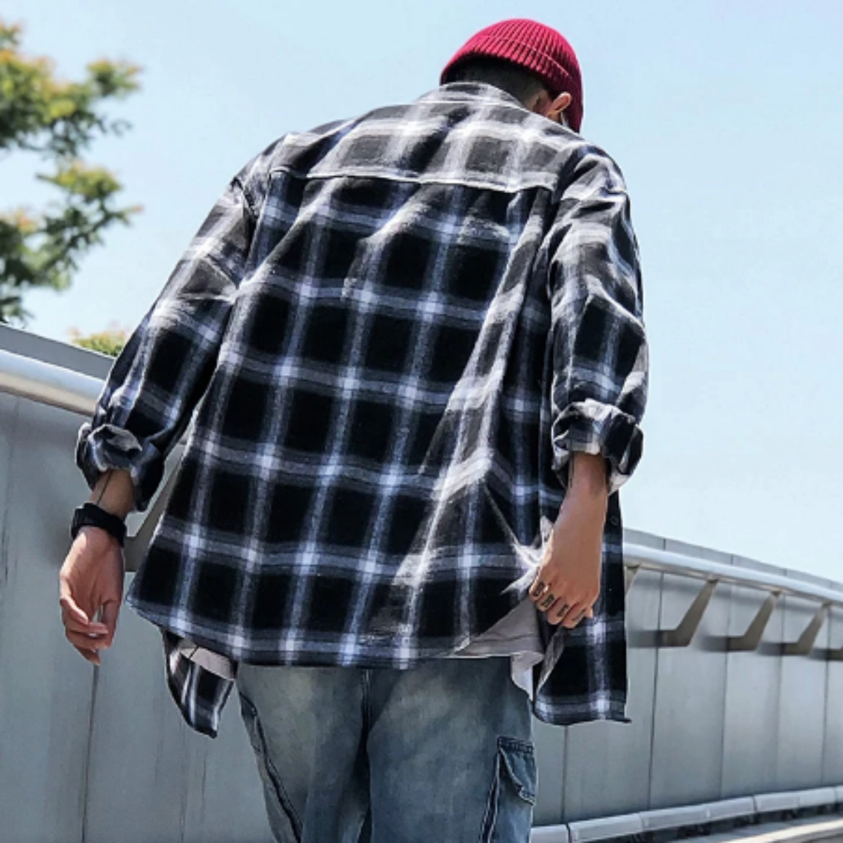 An American Legend Ride enthusiast in a Men's Classic Plaid Flannel Shirt, Black/White walking on a bridge.