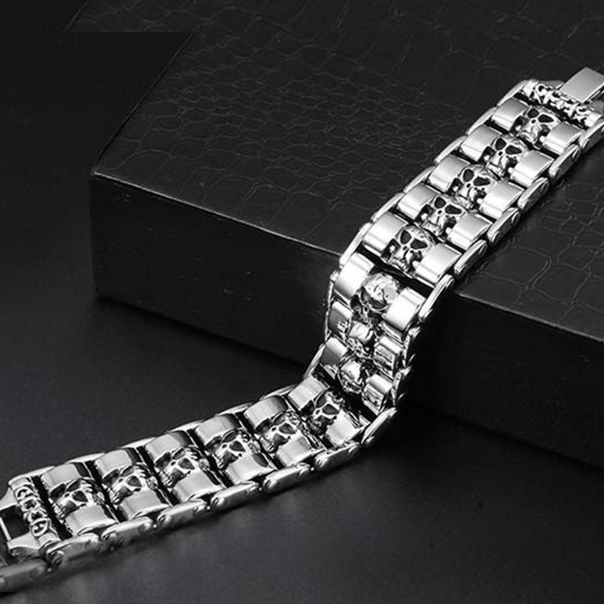 A Stainless Steel Fashion Wide Skull Bracelet, 8.3 x 0.9 in rests on a black, textured surface.