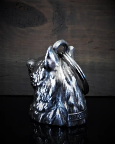 A metal keychain featuring the head of a wolf with detailed fur, crafted from lead-free pewter. The words "Daniel Smart" are engraved at the base. Presented against a wooden surface, this delightful accessory comes in a velveteen drawstring black bag for a touch of elegance.