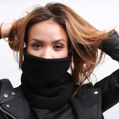 A person wearing the Daniel Smart Dickie - Shielded Tall Neck - Half Chest Back covers their lower face, hands adjusting long brown hair against a plain white background.